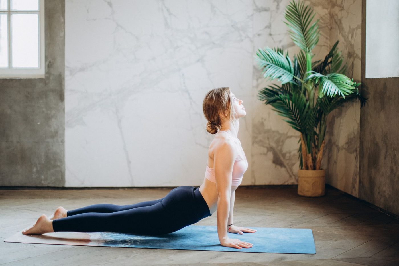 A person in a standing forward fold with both hands on yoga blocks