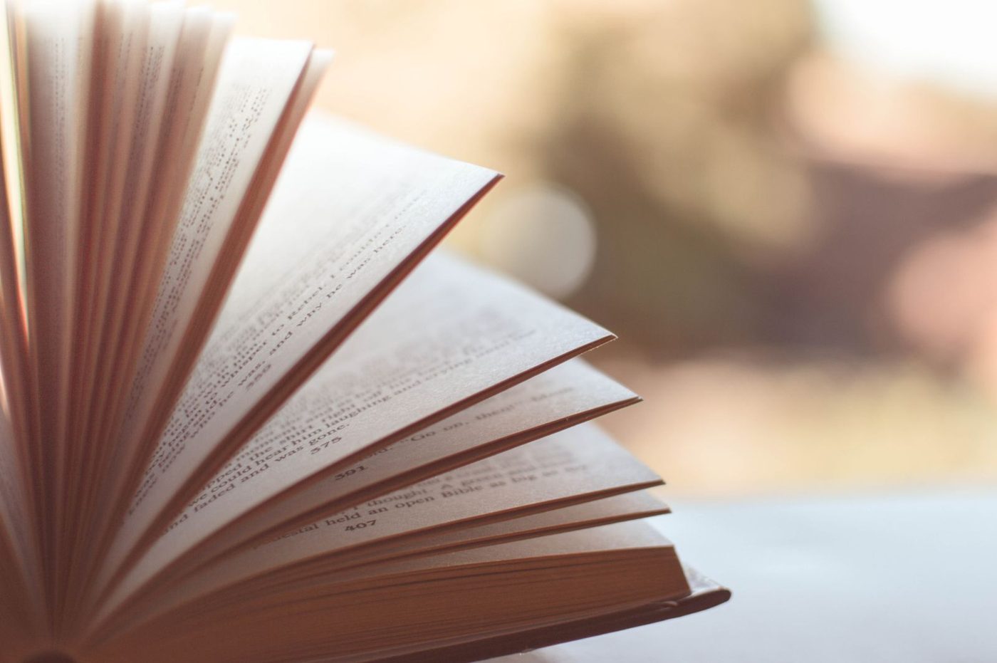 An open book lying flat on a wooden table